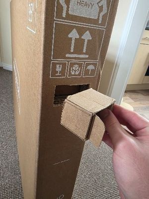 Removal of cardboard squares which lock the top of the Sky Glass box